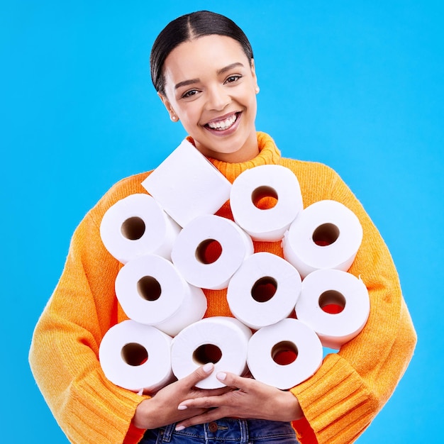 Mulher jovem de papel higiênico e retrato com felicidade e sorriso em um estúdio Fundo azul isolado e mulher feliz e modelo jovem com estoque de rolos de tecido e moda gen z sorrindo