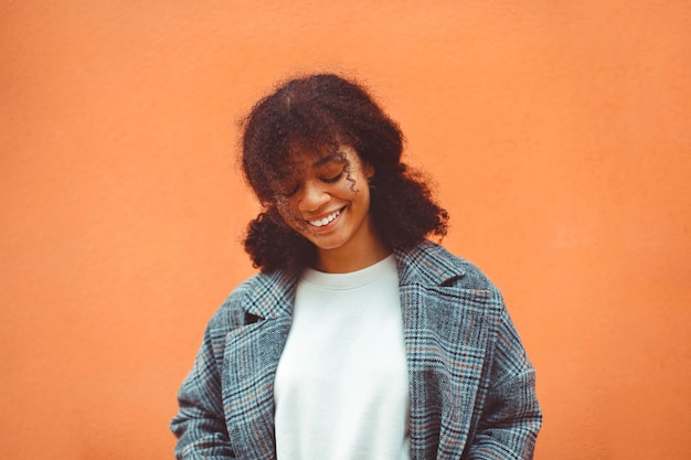Mulher jovem de pé contra um fundo laranja