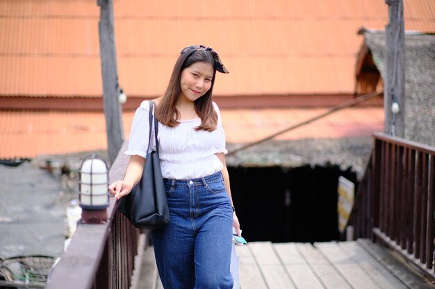 Foto mulher jovem de pé contra uma estrutura construída