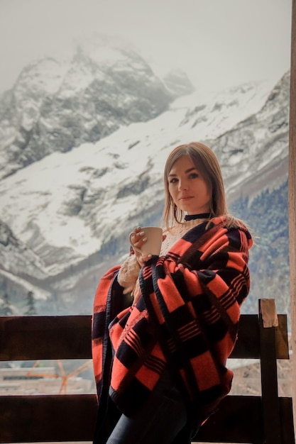 Foto mulher jovem de pé em uma montanha coberta de neve