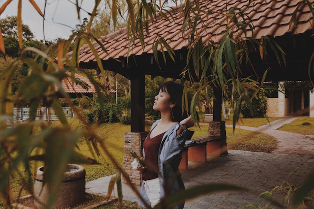 Mulher jovem de pé junto ao gazebo no parque