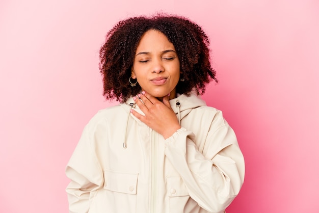 Mulher jovem de raça mista afro-americana isolada sofre de dor na garganta devido a um vírus ou infecção.
