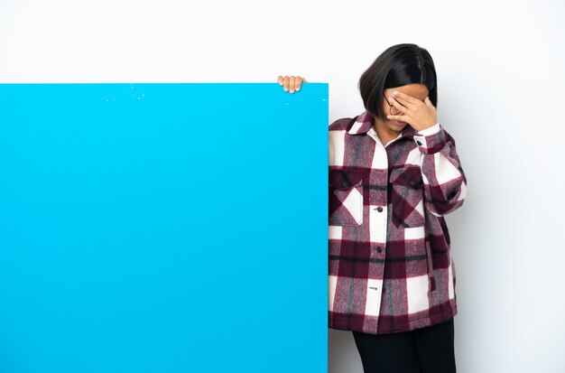 Mulher jovem de raça mista com um grande cartaz azul isolado no fundo branco com dor de cabeça