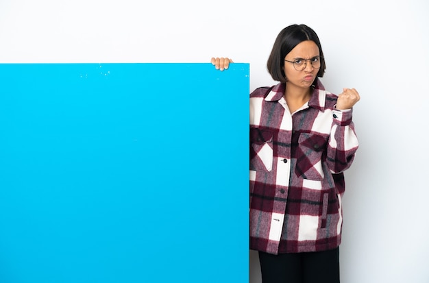 Mulher jovem de raça mista com um grande cartaz azul isolado no fundo branco com uma expressão infeliz