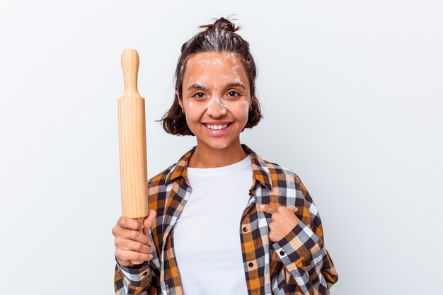 Mulher jovem de raça mista fazendo pão isolado no fundo branco pessoa apontando com a mão para um espaço de cópia de camisa, orgulhosa e confiante