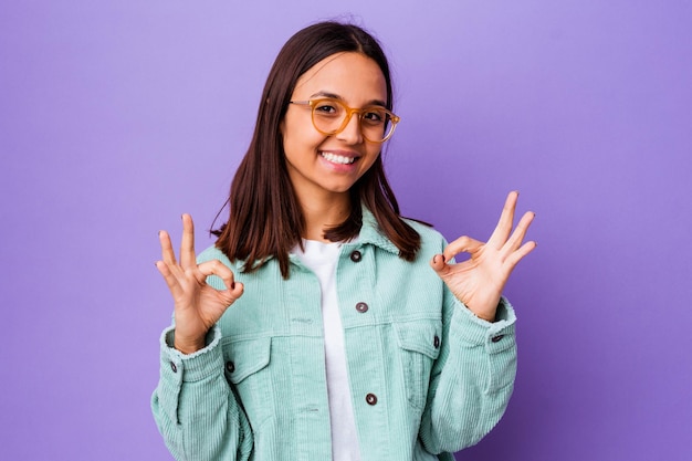 Mulher jovem de raça mista isolada alegre e confiante, mostrando um gesto de aprovação.