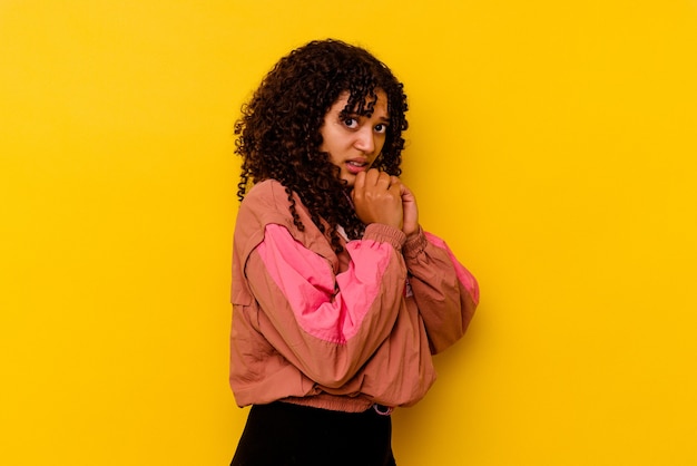 Mulher jovem de raça mista isolada em fundo rosa com medo e com medo.