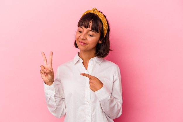 Mulher jovem de raça mista isolada em fundo rosa, fazendo um juramento, colocando a mão no peito.