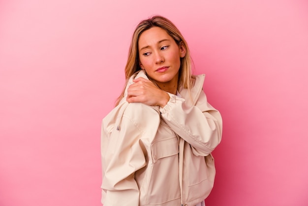 Mulher jovem de raça mista isolada em rosa tendo uma dor no ombro.