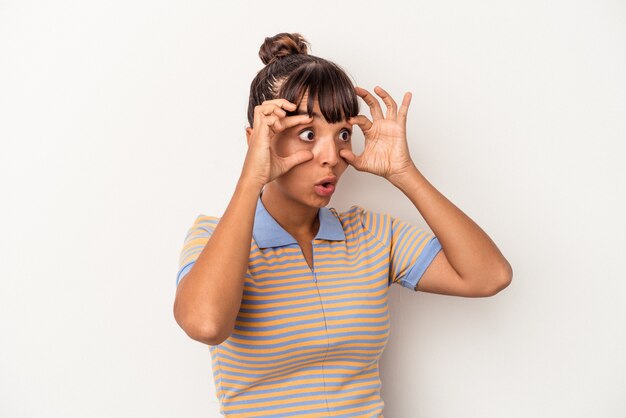 Foto mulher jovem de raça mista isolada no fundo branco, mantendo os olhos abertos para encontrar uma oportunidade de sucesso.