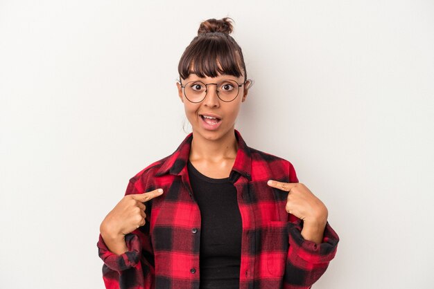 Foto mulher jovem de raça mista isolada no fundo branco surpresa apontando com o dedo, sorrindo amplamente.