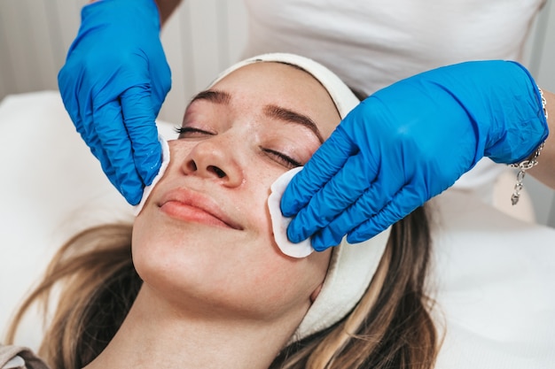Mulher jovem, desfrutando da terapia de rejuvenescimento da pele no centro de cosmetologia.