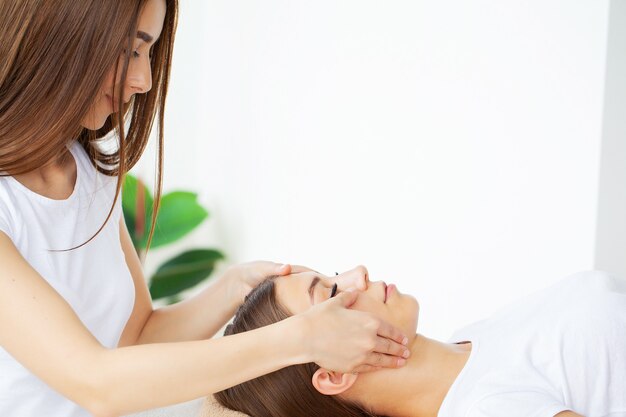 Mulher jovem, desfrutando de uma massagem no salão spa.