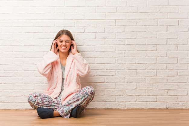 Mulher jovem, desgastar, pyjama, cobertura, orelhas, com, mãos