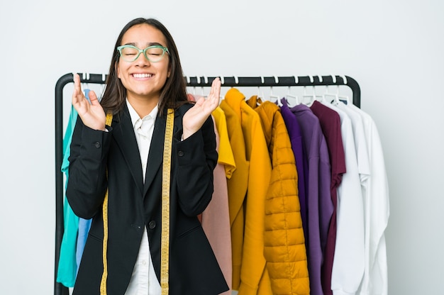 Mulher jovem designer asiática isolada na parede branca alegre rindo muito