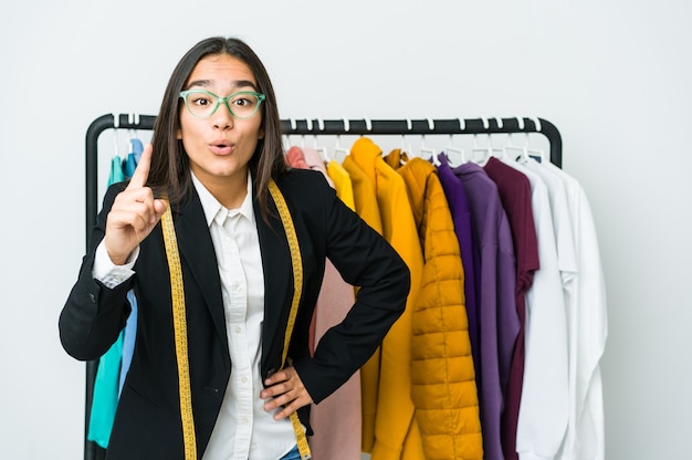 Mulher jovem designer asiática isolada na parede branca, tendo uma ideia, um conceito de inspiração