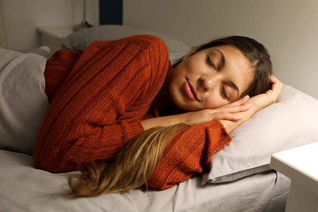 Foto mulher jovem dormindo pacificamente na cama