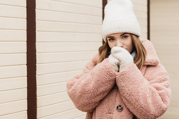 Mulher jovem e adorável em pé na rua nas férias de inverno