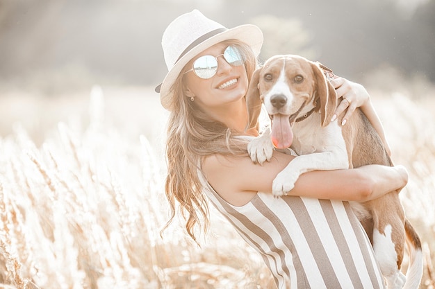 Mulher jovem e atraente ao ar livre com seu animal de estimação proprietário e cachorro juntos amigos para sempre lady e beagle