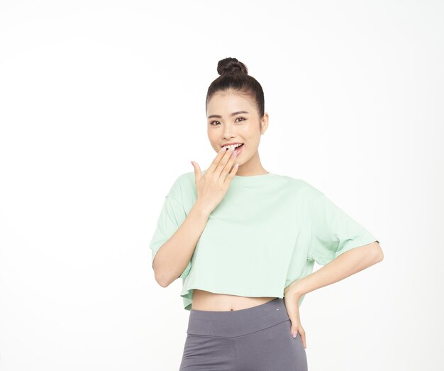 Mulher jovem e atraente asiática com gesto de mão e expressão de rosto bonito em roupa esportiva isolada em fundo branco