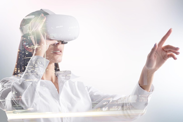 Mulher jovem e atraente caucasiana com óculos VR apontando para fundo abstrato luz branca da cidade Realidade virtual e conceito de experiência Dupla exposição