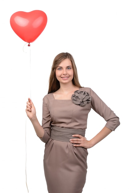 Mulher jovem e atraente com balão em forma de coração.