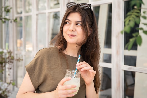Mulher jovem e atraente com um copo de limonada em um dia quente de verão