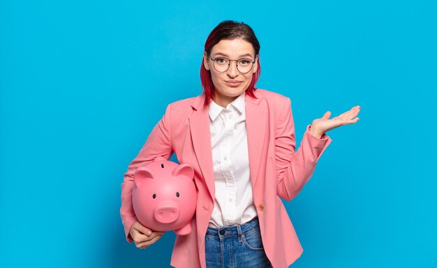 Mulher jovem e atraente de cabelo vermelho sentindo-se perplexa e confusa, duvidando, ponderando ou escolhendo diferentes opções com expressão engraçada. conceito de negócio bem-humorado.