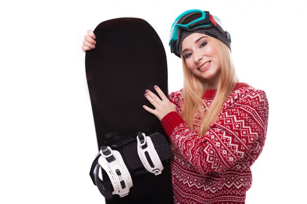 Mulher jovem e atraente de camisola vermelha e óculos de esqui azuis segurar snowboard