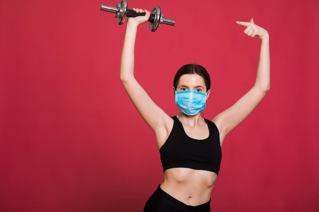 mulher jovem e atraente em roupas esportivas esticando os músculos antes de treinar em vermelho