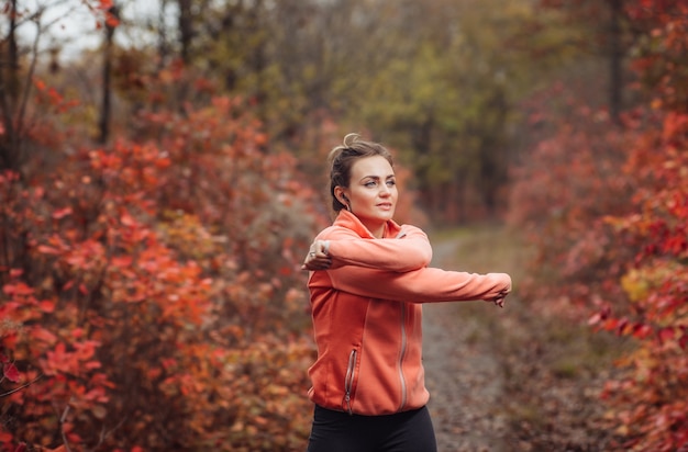 Mulher jovem e atraente em roupas esportivas fazendo exercícios de alongamento para as mãos