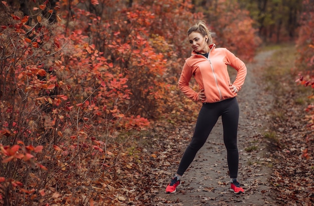 Mulher jovem e atraente em roupas esportivas fazendo exercícios de alongamento