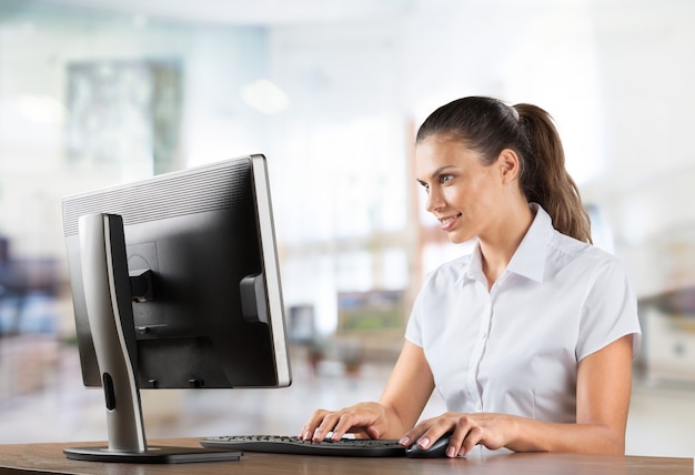 Mulher jovem e atraente falando ao telefone e usando o laptop