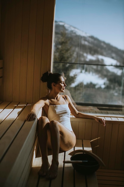 Mulher jovem e atraente relaxante na sauna