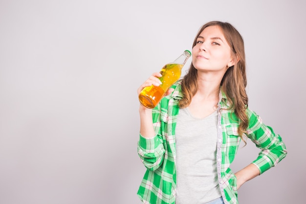 Mulher jovem e atraente segurando uma garrafa de cerveja.