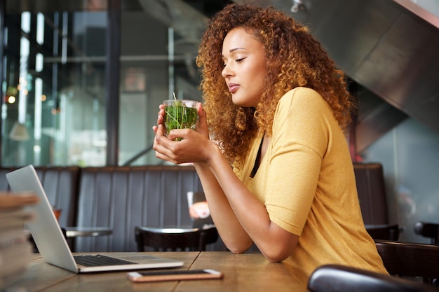 mulher jovem e atraente sentada no café tomando chá