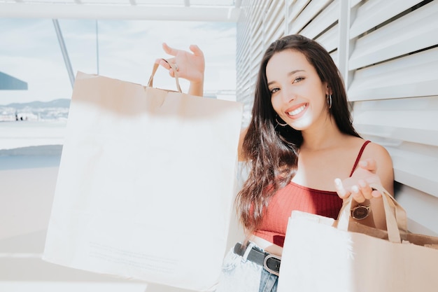 Mulher jovem e bonita africana com sacolas de compras no shopping de rua da cidade. Copie o espaço, as compras de Natal de ano novo apresentam o conceito, o dia de compras de roupas novas. Estilo moderno e conceitos de mulher jovem