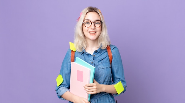 Mulher jovem e bonita albina parecendo feliz e agradavelmente surpresa. conceito de estudante