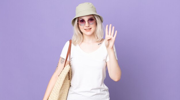 Mulher jovem e bonita albina sorrindo e parecendo amigável, mostrando o número quatro. conceito de verão