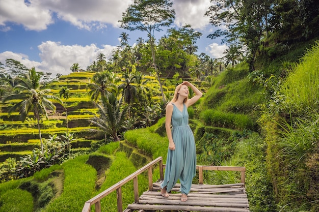 Mulher jovem e bonita anda na típica encosta asiática com arroz em forma de montanha em forma de montanha verde cascata terraços arrozais Ubud Bali Indonésia Bali conceito de viagem