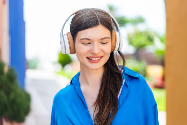 Mulher jovem e bonita ao ar livre a ouvir música.