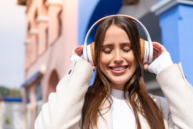 Mulher jovem e bonita ao ar livre ouvindo música