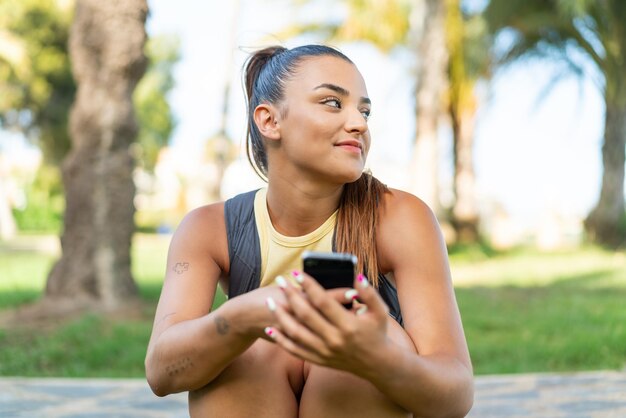 Mulher jovem e bonita ao ar livre usando telefone celular