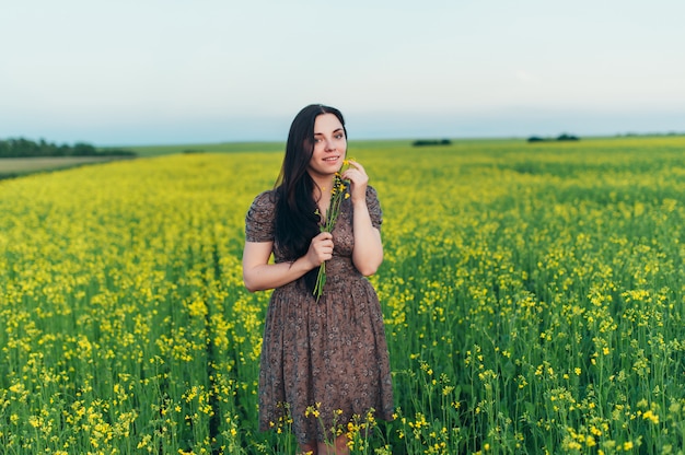 Mulher jovem e bonita ao pôr do sol no campo