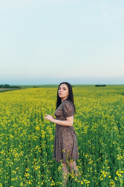 Mulher jovem e bonita ao pôr do sol no campo