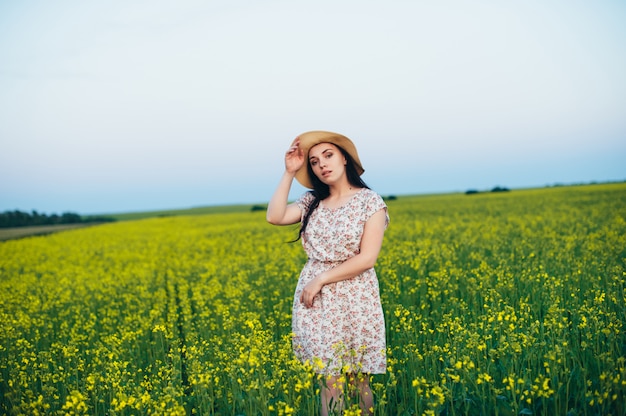 Mulher jovem e bonita ao pôr do sol no campo