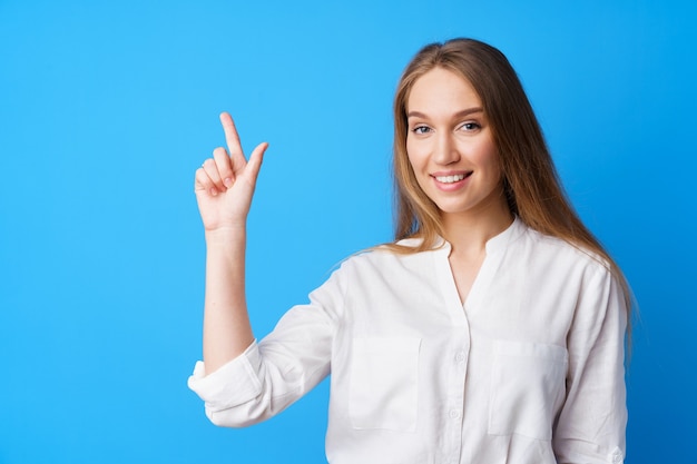 Mulher jovem e bonita apontando para copiar o espaço para publicidade