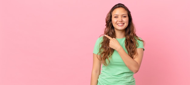 Foto mulher jovem e bonita apontando para o espaço da cópia