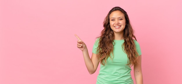 Mulher jovem e bonita apontando para o espaço da cópia