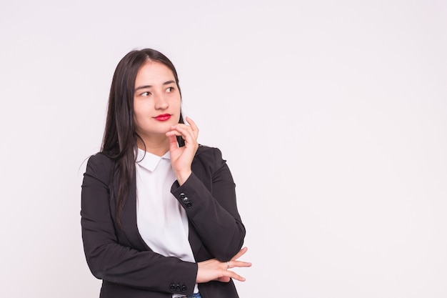 Mulher jovem e bonita asiática sorridente com a mão no queixo